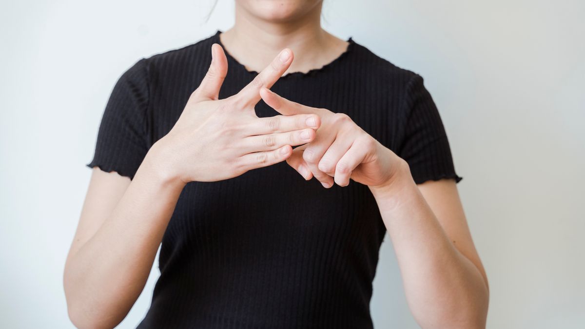 Femme en train de signer, mains au premier plan, comme pour dire merci en langue des signes