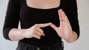 Femme qui signe des deux mains, comme lors d'un exercice pour apprendre la langue des signes gratuitement
